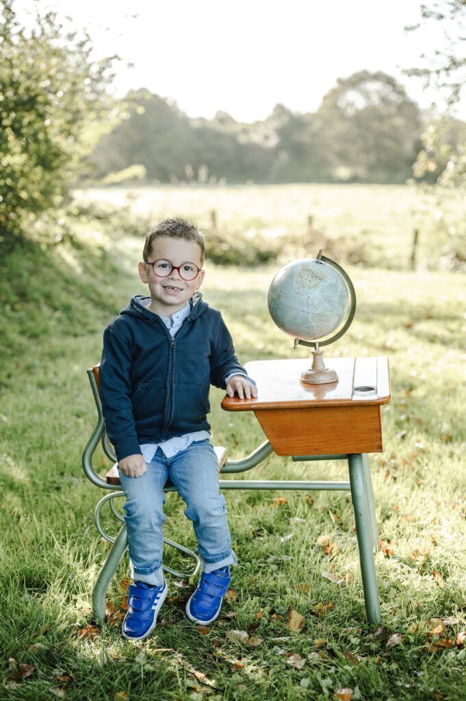 Marie_Blouin_Photographie_Normandie_Ecole_1 Garçon sur son bureau avec un globe terrestre